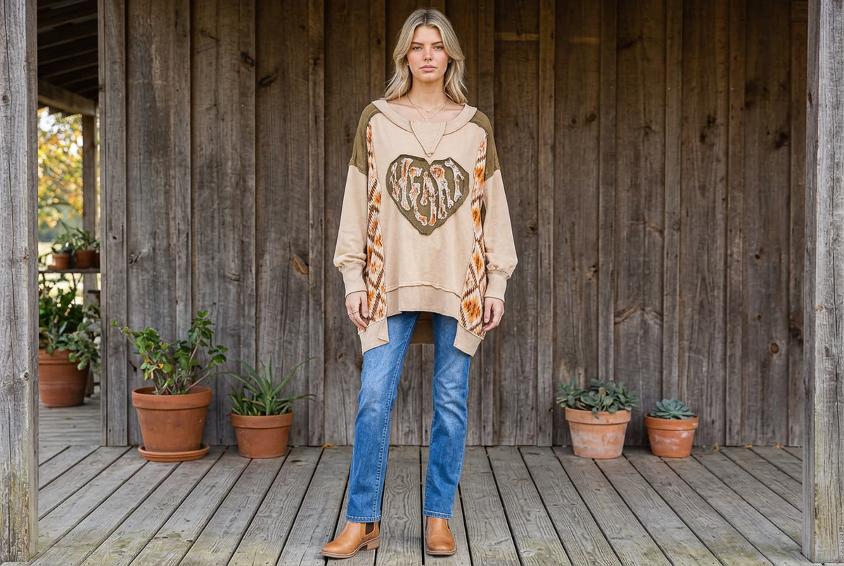 Coffee heart patchwork pullover worn with blue jeans and tan boots on a timber porch with potted plants
