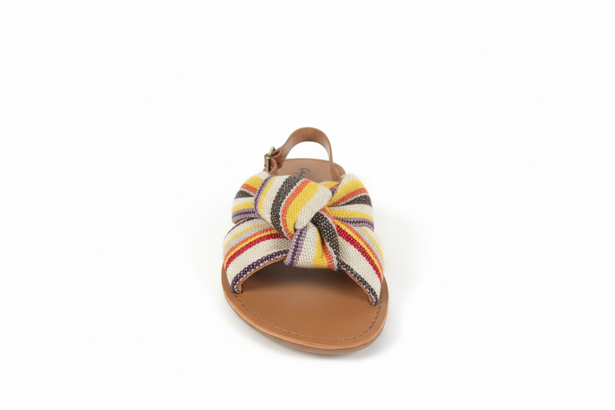 Women's striped fabric slide sandals front view showing colorful yellow orange red black stripes and brown leather sole