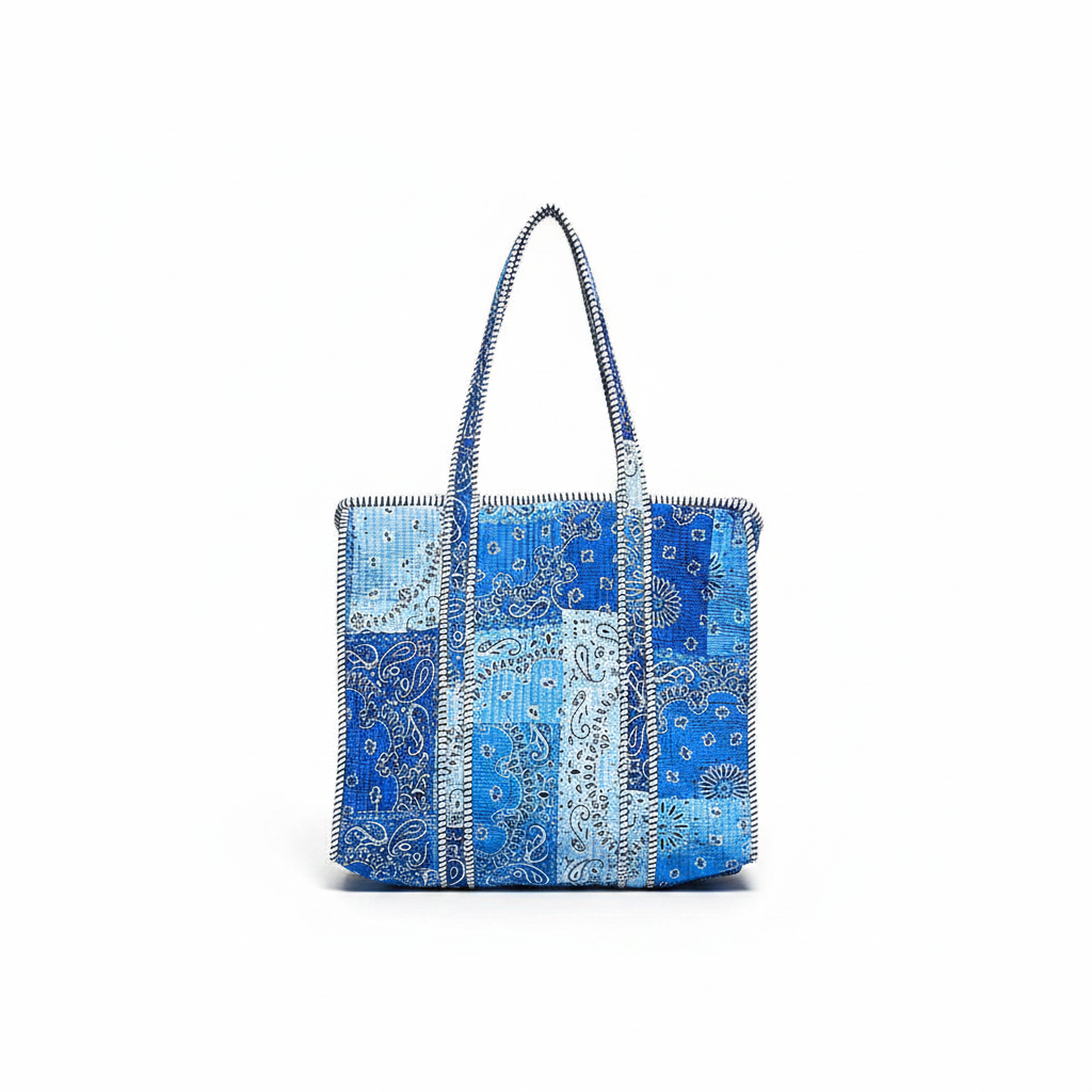 Women's quilted paisley print tote bag back panel view, stitching and hardware detail, white studio background