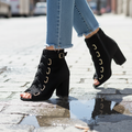 Woman wearing black peep-toe lace-up ankle booties with distressed jeans - street style editorial photo