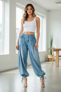 Woman wearing light wash wide-leg denim cargo pants styled with white tank top and heels