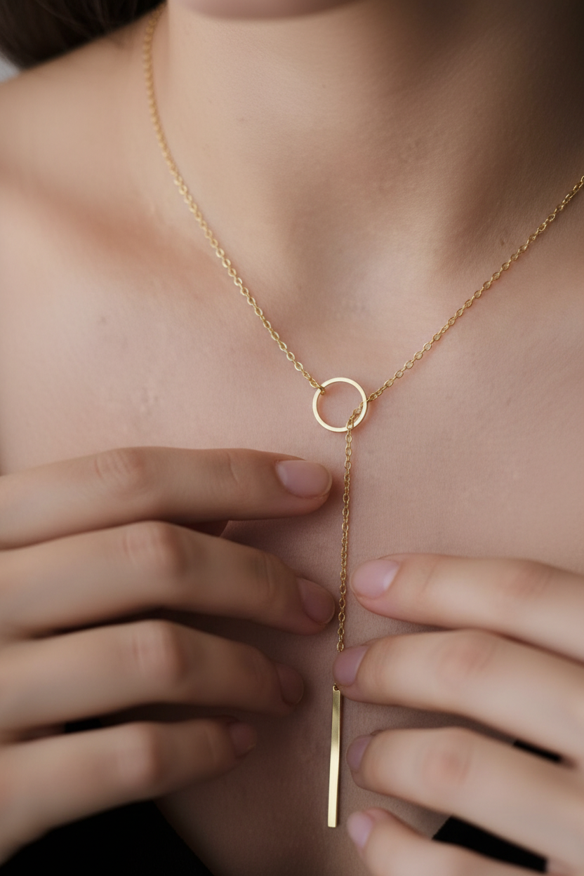 Close-up detail of gold tone lariat necklace worn on model