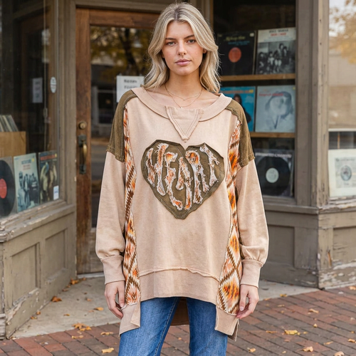 Tan heart patchwork pullover with patterned side panels, worn with jeans outside a record shop