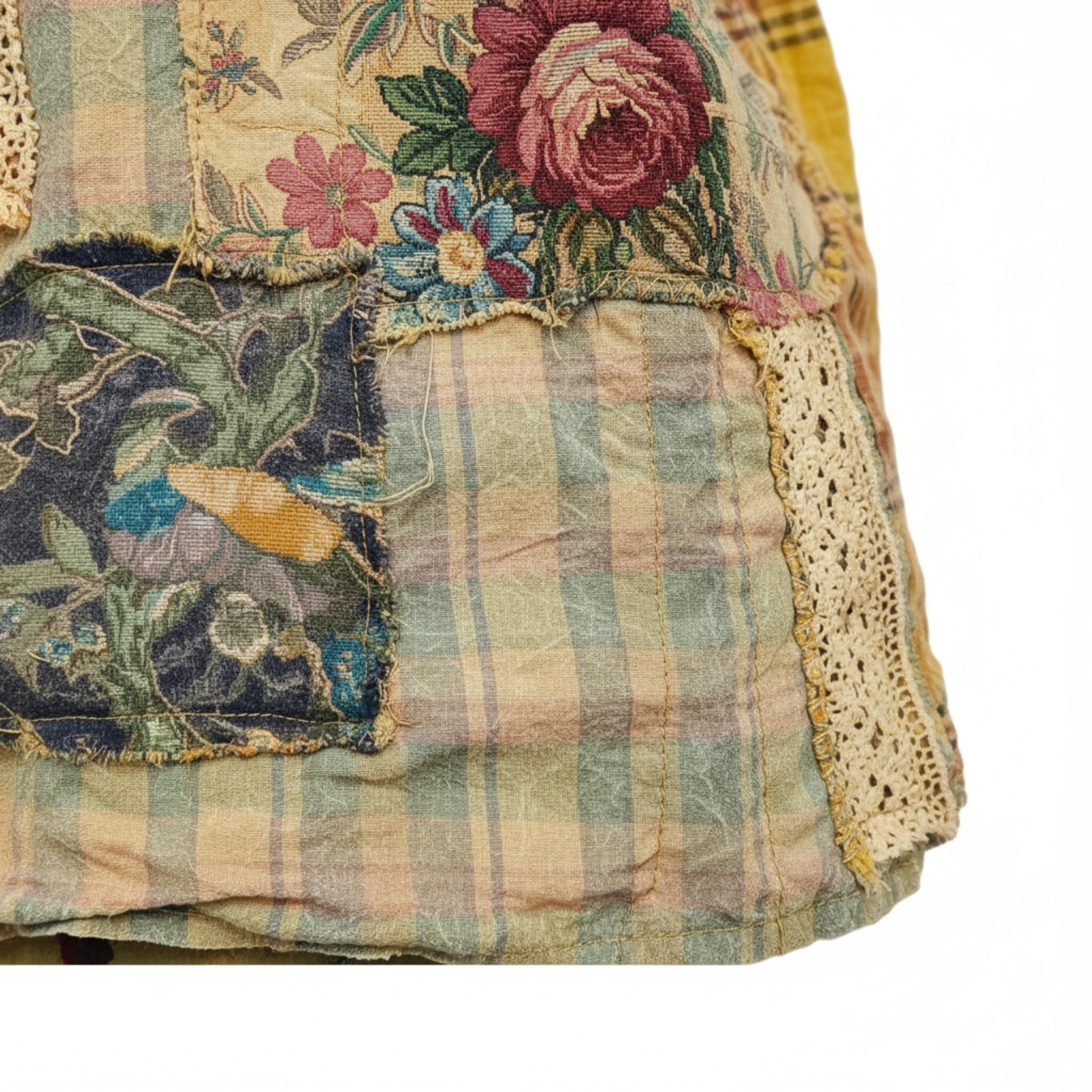 Close-up of golden olive patchwork jacket, mixed floral tapestry and plaid panels, lace trim, raw frayed seams