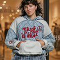 Close-up of Take It Easy embroidery and peace sign on POL Clothing quilted denim hoodie front