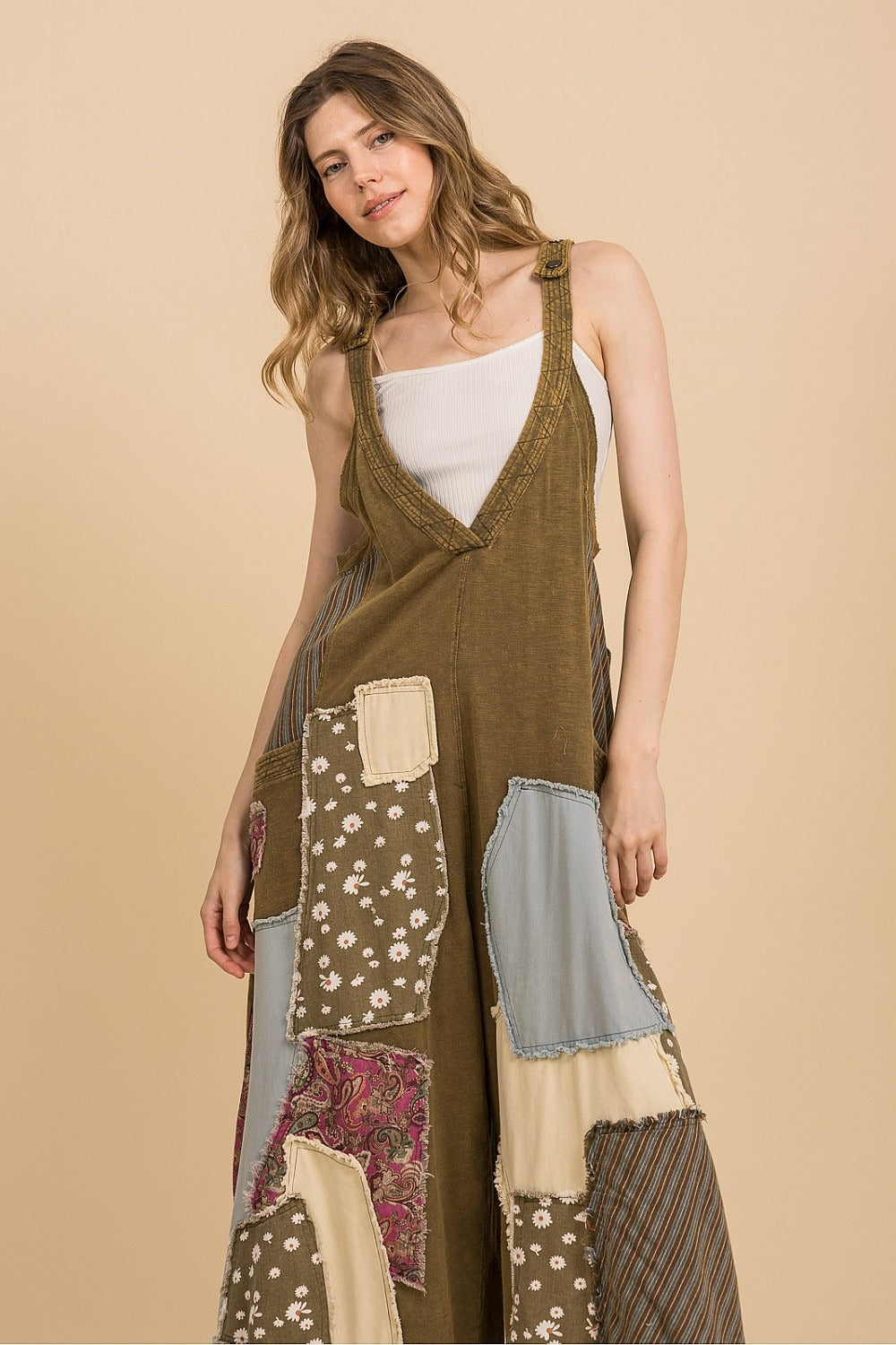 Woman wearing a patchwork dress with a beige background