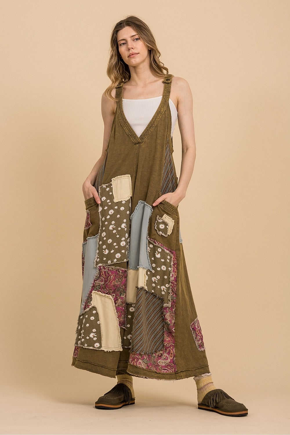 Woman wearing a long, patterned dress against a beige background