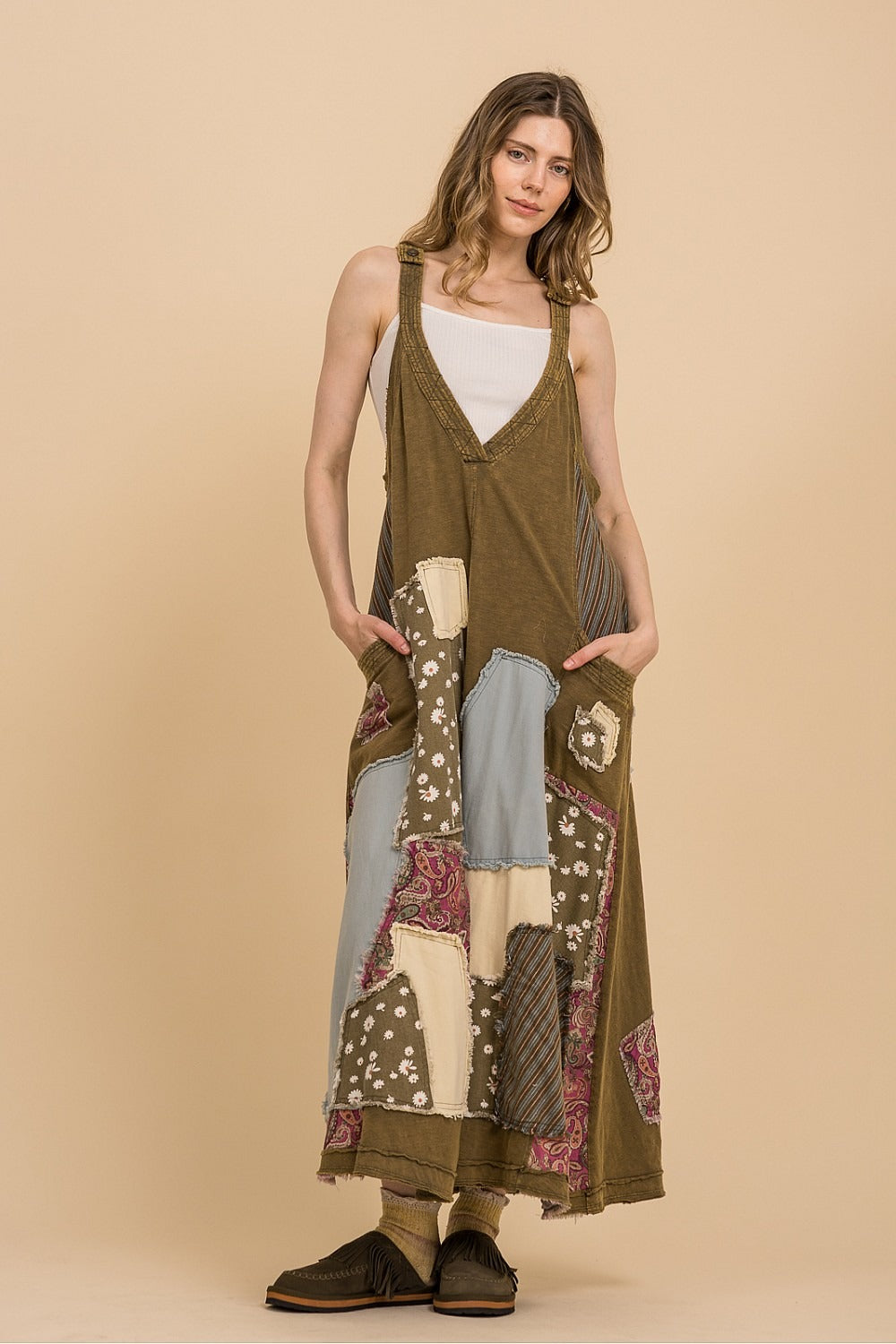 Woman wearing a long, patterned dress against a beige background