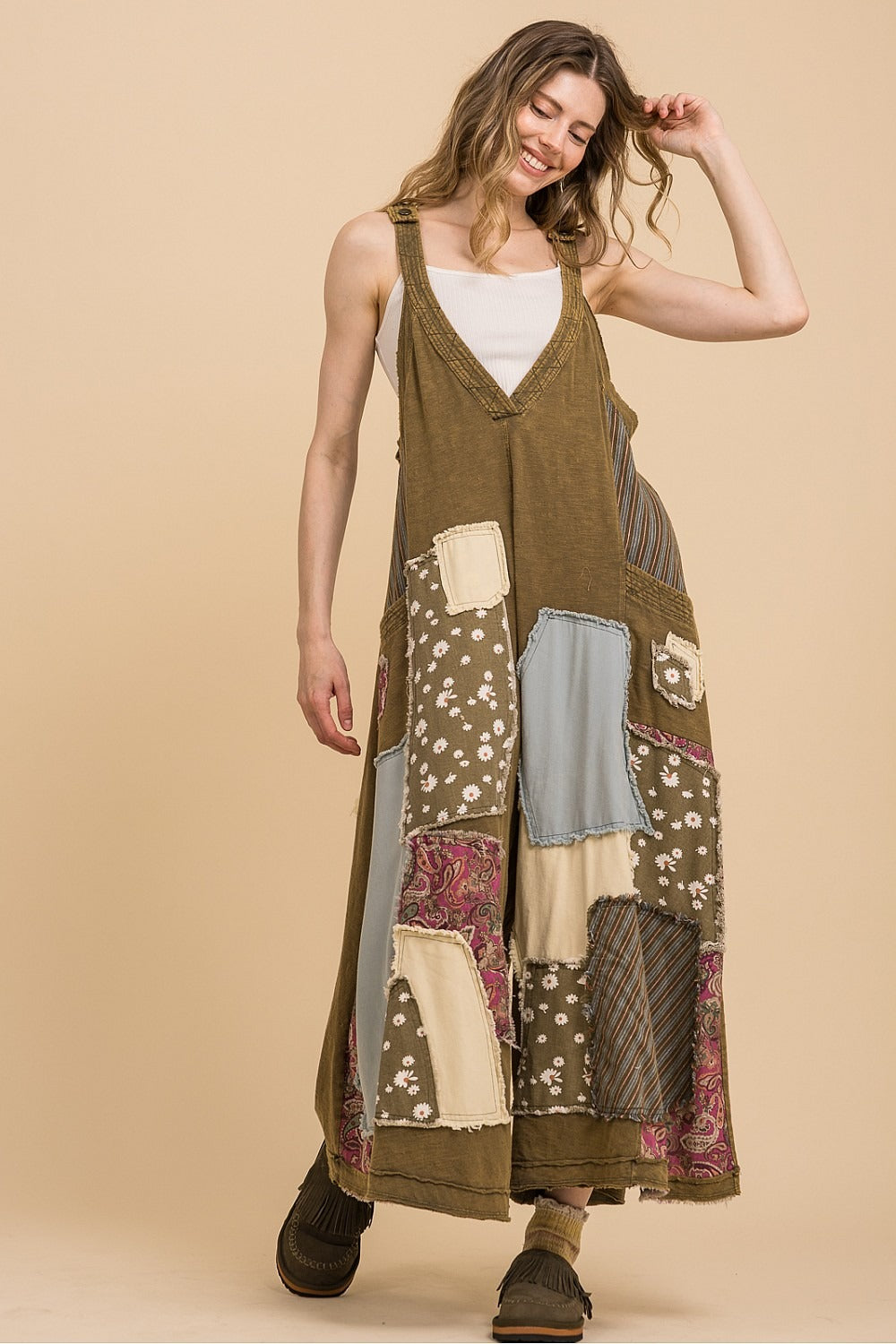 Woman wearing a patchwork dress against a beige background