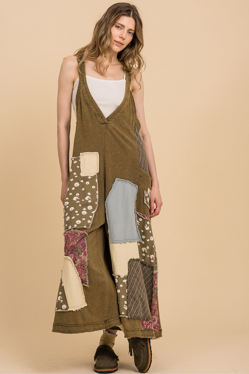 Woman wearing a patchwork dress on a beige background