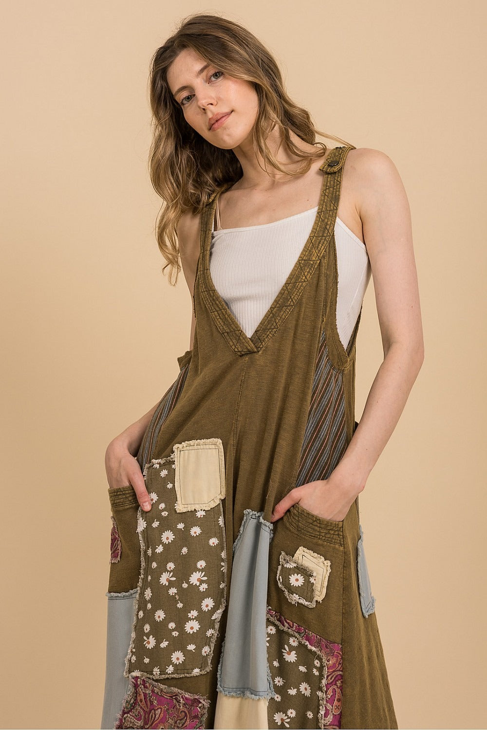 Woman wearing a green patterned dress against a beige background