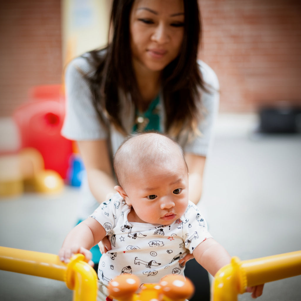 Woman and baby playing with toys on a colorful play mat