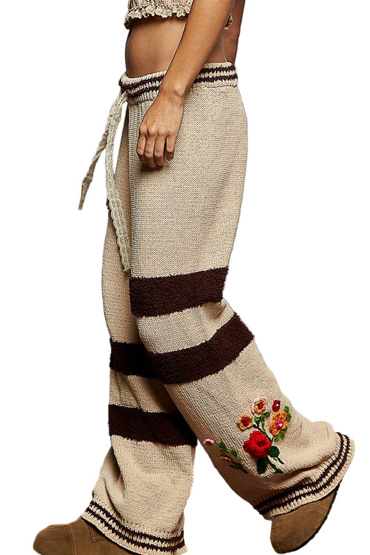 Beige and brown striped pants with floral embroidery on a white background