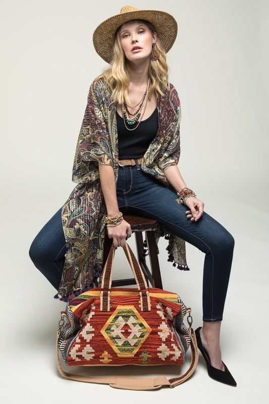 Crafted with a classic Navajo-inspired pattern, this stunning duffel bag offers short straps, adjustable shoulder straps, two inside slip pockets, and a zippered pocket.