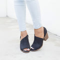 Qupid Black peep-toe cutout ankle bootie on model with cuffed light wash jeans, outer V cutout and block heel visible
