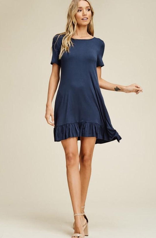 A blonde girl modeling a solid ruffle baby doll mini dress.